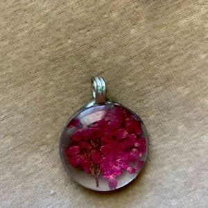 Beautiful glass pendant with pressed pink flowers.